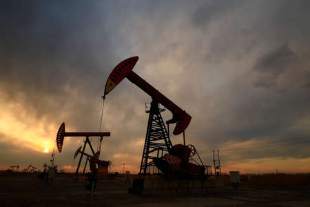 Is operation of pumping unit, sunset in oil field の写真素材