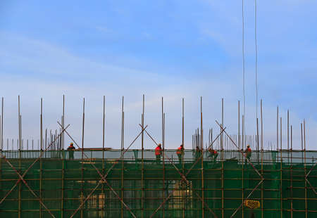 Cranes at construction sites, silhouetted at sunriseの写真素材