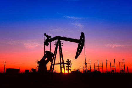 The pumping unit is working, in the silhouette of sunsetの写真素材