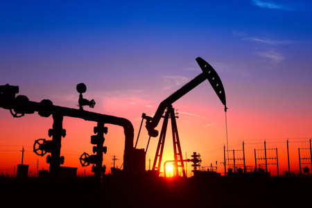 The pumping unit is working, in the silhouette of sunsetの写真素材