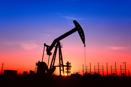 The pumping unit is working, in the silhouette of sunsetの写真素材