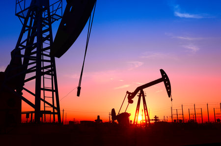 The pumping unit is working, in the silhouette of sunsetの写真素材