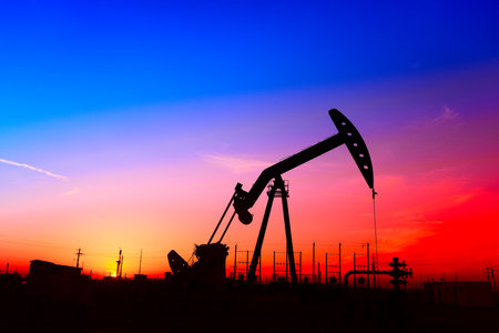 The pumping unit is working, in the silhouette of sunsetの写真素材