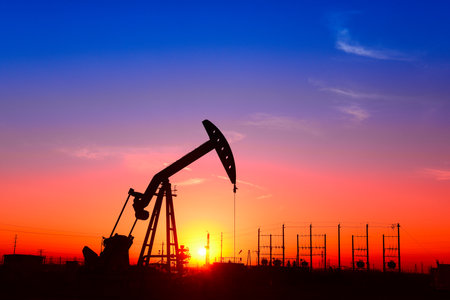 The pumping unit is working, in the silhouette of sunsetの写真素材