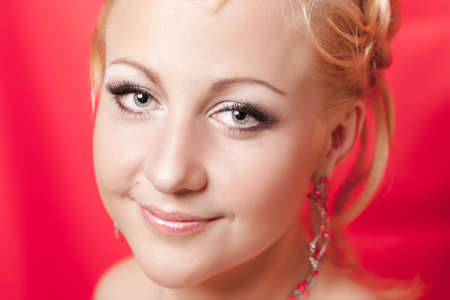 Portrait of the girl with a smile on a red backgroundの写真素材