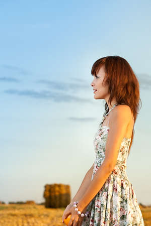 Portrait of the girl in the field in solar weatherの写真素材