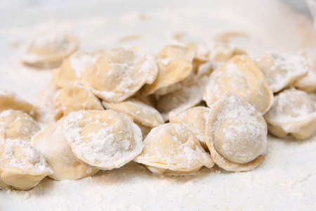 Hill of pelmeni in a flour, ready to preparationの写真素材