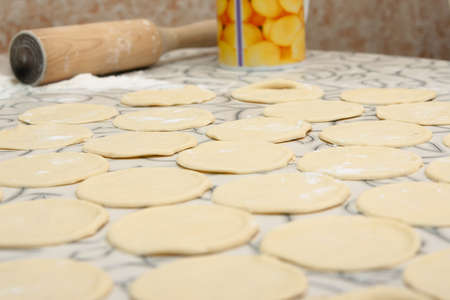 Round shape of the dough and rolling pin with flour on the tableの写真素材