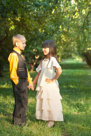 Portrait of a little boy and girl in beautiful dressの写真素材