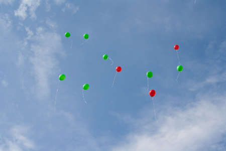 Red and green balloons in the skyの写真素材