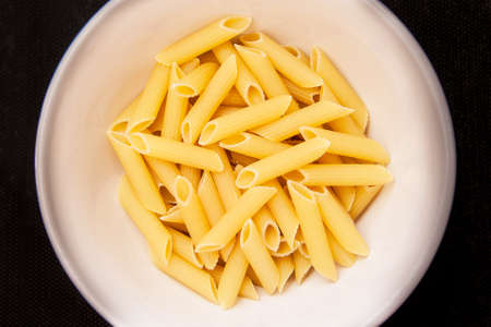 Yellow macaroni, vermicelli food background in dishの写真素材