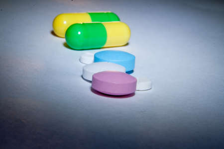 Colored pills on paper macroの写真素材