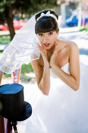The bride brunette stares at the hat-cylinderの写真素材
