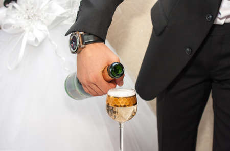 Pouring champagne into a glass on a wedding celebrationの写真素材