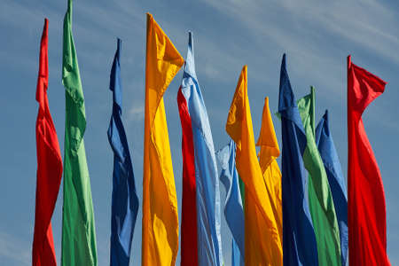 Many flags against the blue cloudy sky
