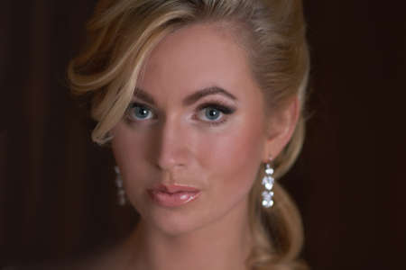 Beautiful woman with blond hair  on dark backgroundの写真素材