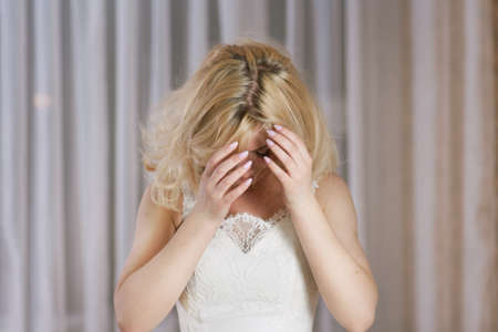 Shaggy beautiful woman with blond hair  on light backgroundの写真素材