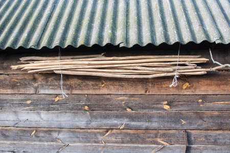 Old wall texture with a roof hanging the wood cuttingsの写真素材
