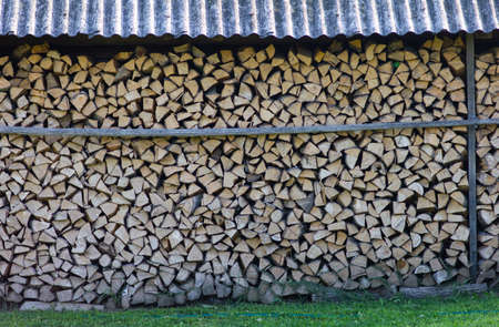 Rustic log firewood near the wallの写真素材