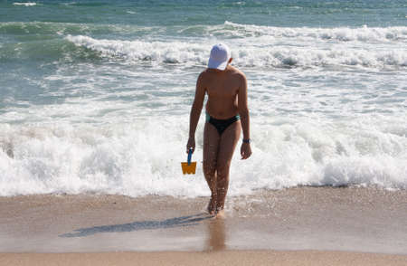 The guy a teenager on background of blue sky in clear weather is on the shore.の写真素材