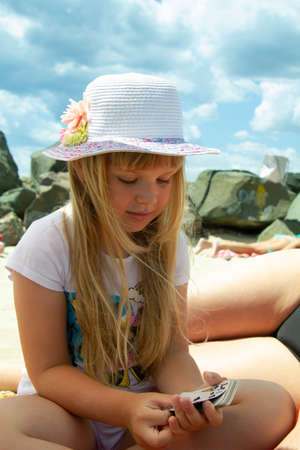 Little girl on the beach playing with cardsの写真素材