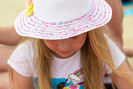 A girl in a light hat on the beach.の写真素材
