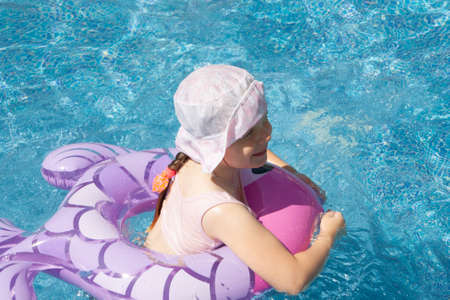 A girl with an inflatable circle and a boy play in the pool.の写真素材