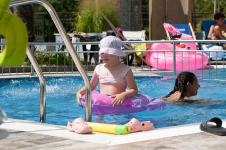A girl with an inflatable circle and a boy play in the pool.の写真素材