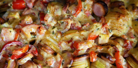 Potatoes and sausages on a baking sheet.の写真素材