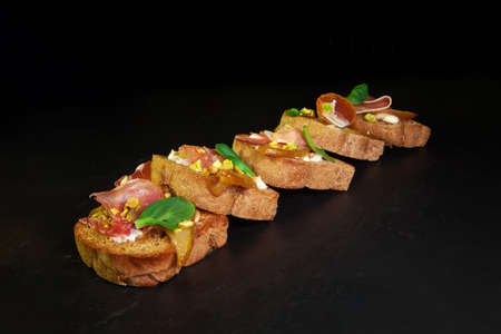 Whole grain bread sandwiches with ham, bacon, prosciutto, olives and olivesの写真素材