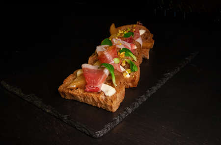 Whole grain bread sandwiches with ham, bacon, prosciutto, olives and olivesの写真素材
