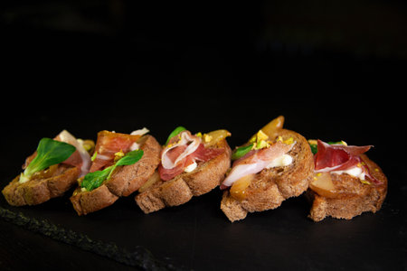 Whole grain bread sandwiches with ham, bacon, prosciutto, olives and olivesの写真素材