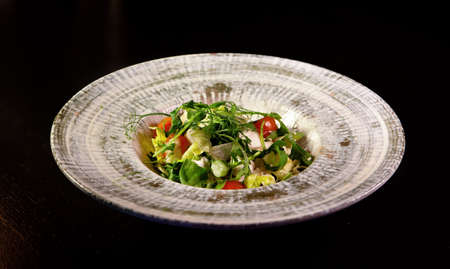 A fresh vegetable salad. A mix of tomatoes, green lettuce, arugula, radishes and seeds. Healthy vegetarian foodの写真素材