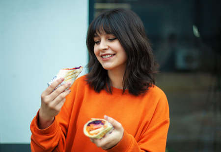 A young smiling girl holds vegetarian rolls.の写真素材