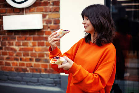 A young smiling girl holds vegetarian rolls.の写真素材