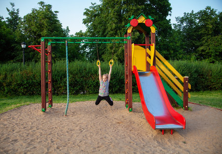 Cute little girl having fun on a playground outdoors in summerの写真素材