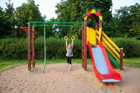 Cute little girl having fun on a playground outdoors in summerの写真素材