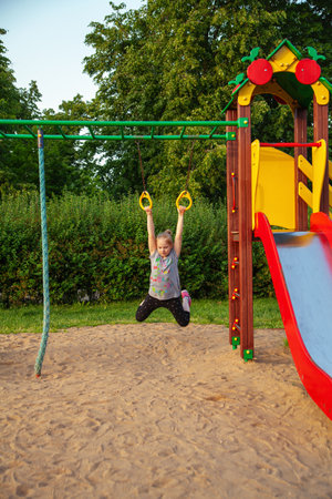 Cute little girl having fun on a playground outdoors in summerの写真素材