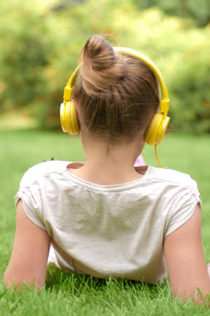 Relaxed young woman listening music in parkの写真素材