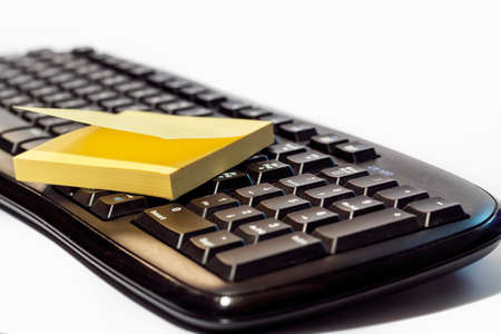 Yellow sticky note post on computer keyboardの写真素材