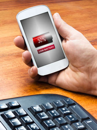 A man holding phone  with a low battery icon in the screen,