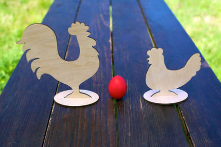 red egg, chicken and rooster on the tableの写真素材