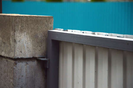 Gray metal gate attached to a stone fenceの写真素材