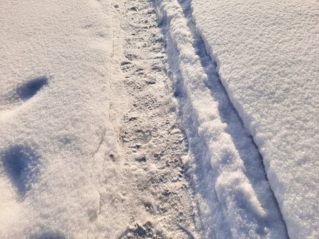 A path with fresh footprints in the snow in winterの写真素材