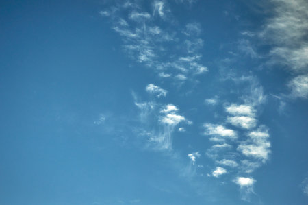 White fluffy clouds on a blue sky backgroundの写真素材
