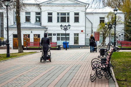Young mothers walking with strollers near a historic building in Ulyanovskの写真素材
