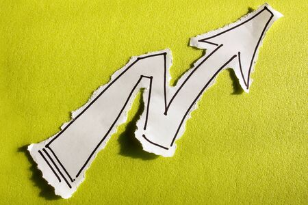 SKETCH made by a child, Paper Arrow draw on a cut out white piece of paper shot on a bright green