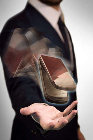 Wireless Phone flying in the palm of a business man which have the complete control of communicationの写真素材