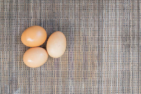 Three chicken egg lay on table cloth. Can be as background for farm, health, food, life, and nature.の写真素材