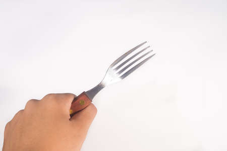Hand holding Stainless Steel Fork on White Backgroundの写真素材